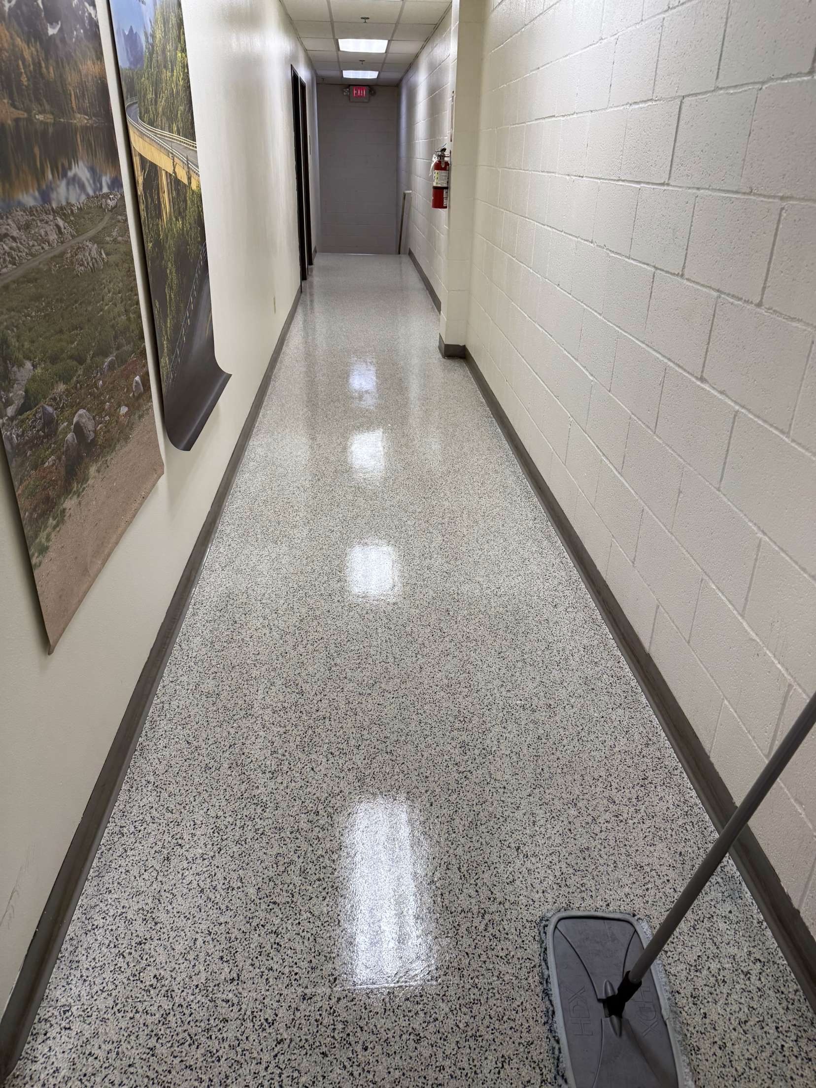 Gleaming commercial hallway after cleaning — polished VCT floors