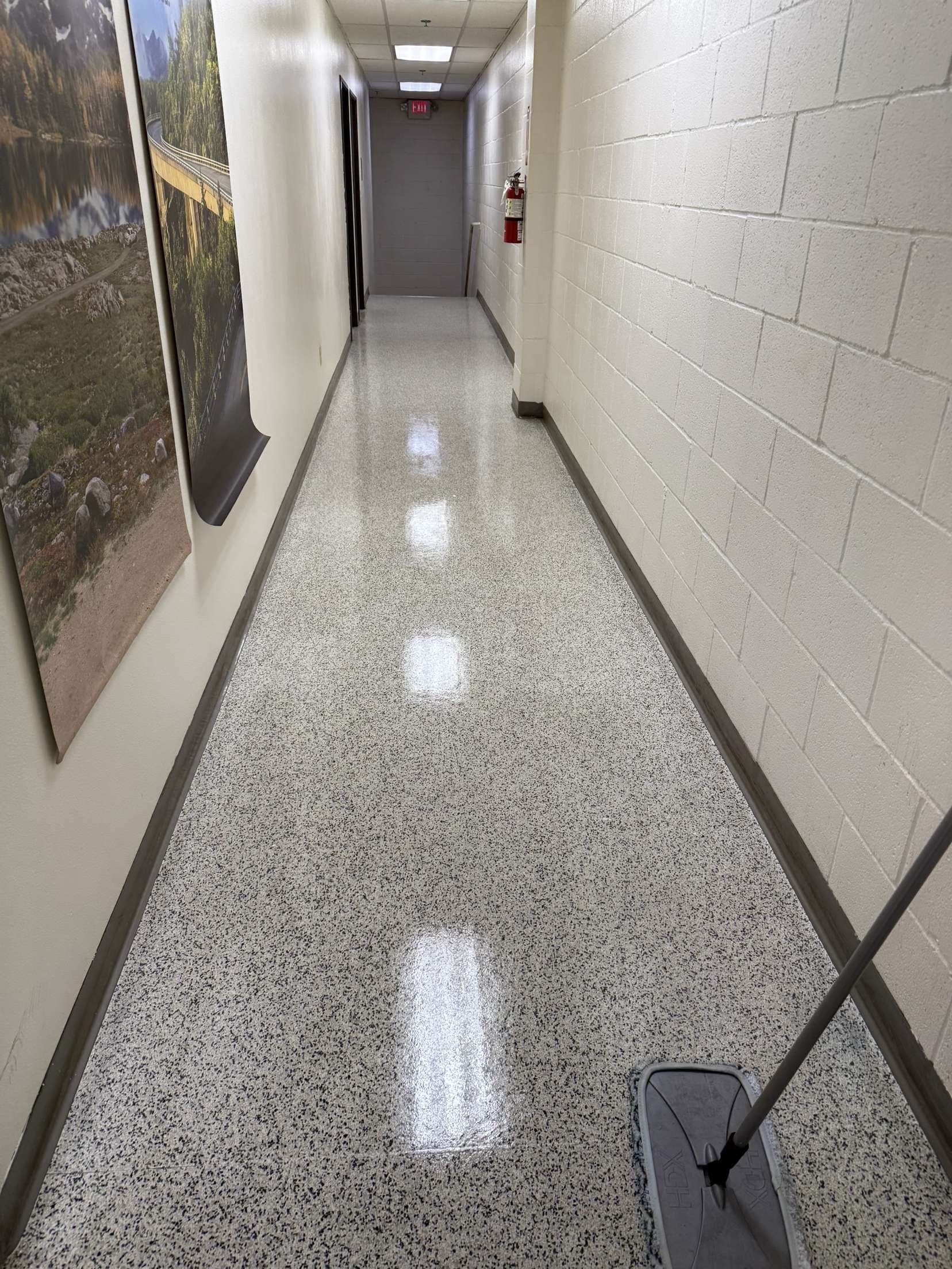Gleaming commercial hallway after cleaning — polished VCT floors