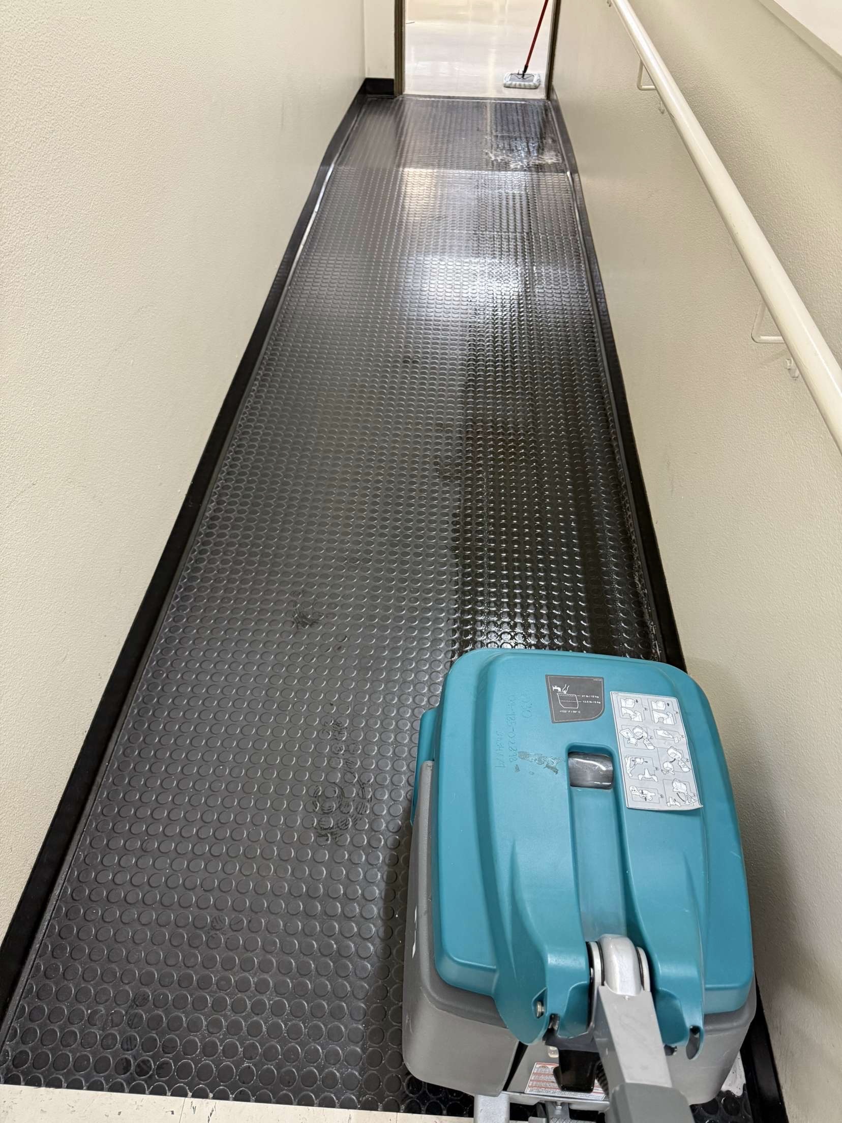 Floor scrubber on rubber coin matting — professional-grade equipment