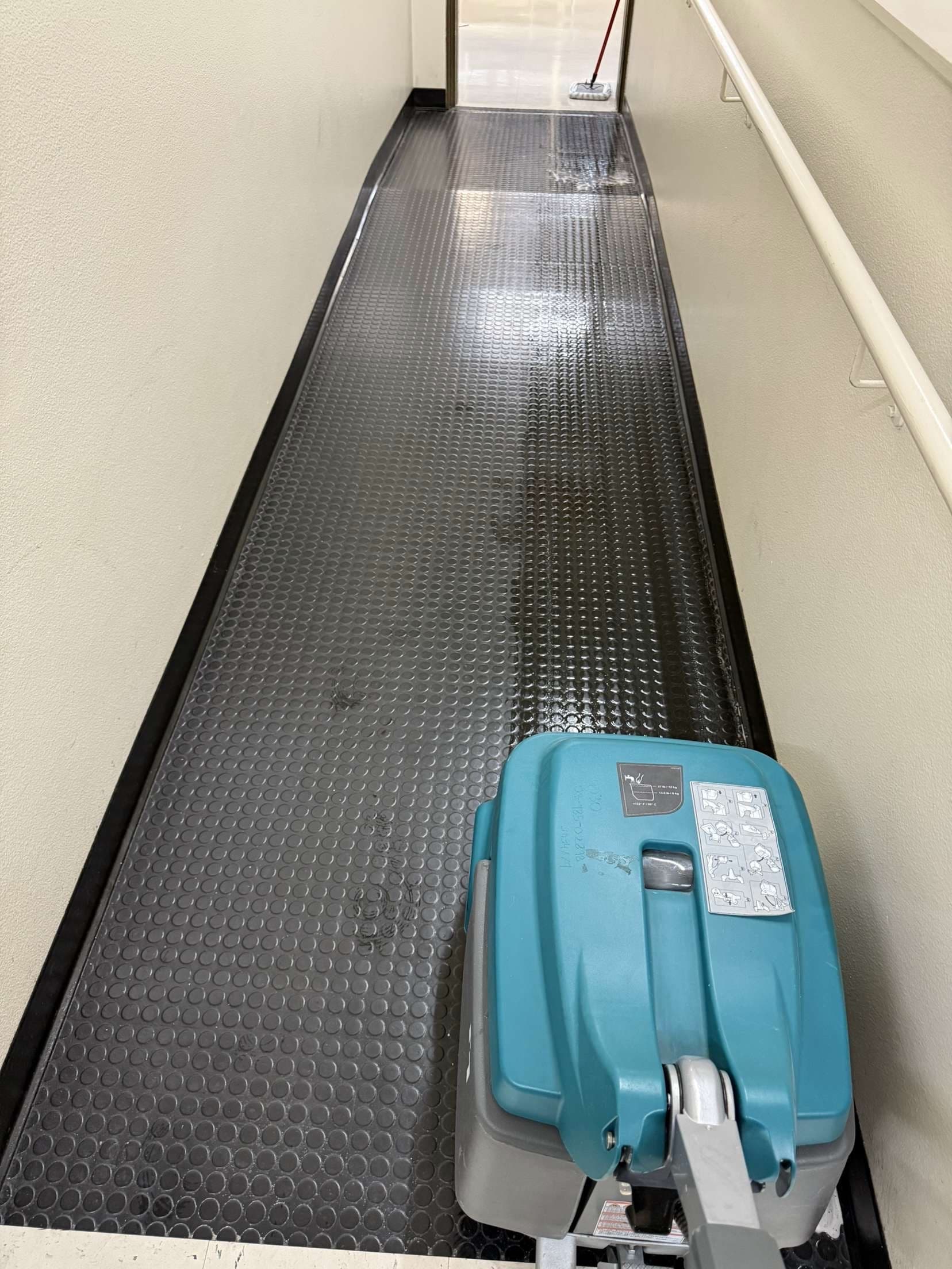 Floor scrubber on rubber coin matting — professional-grade equipment
