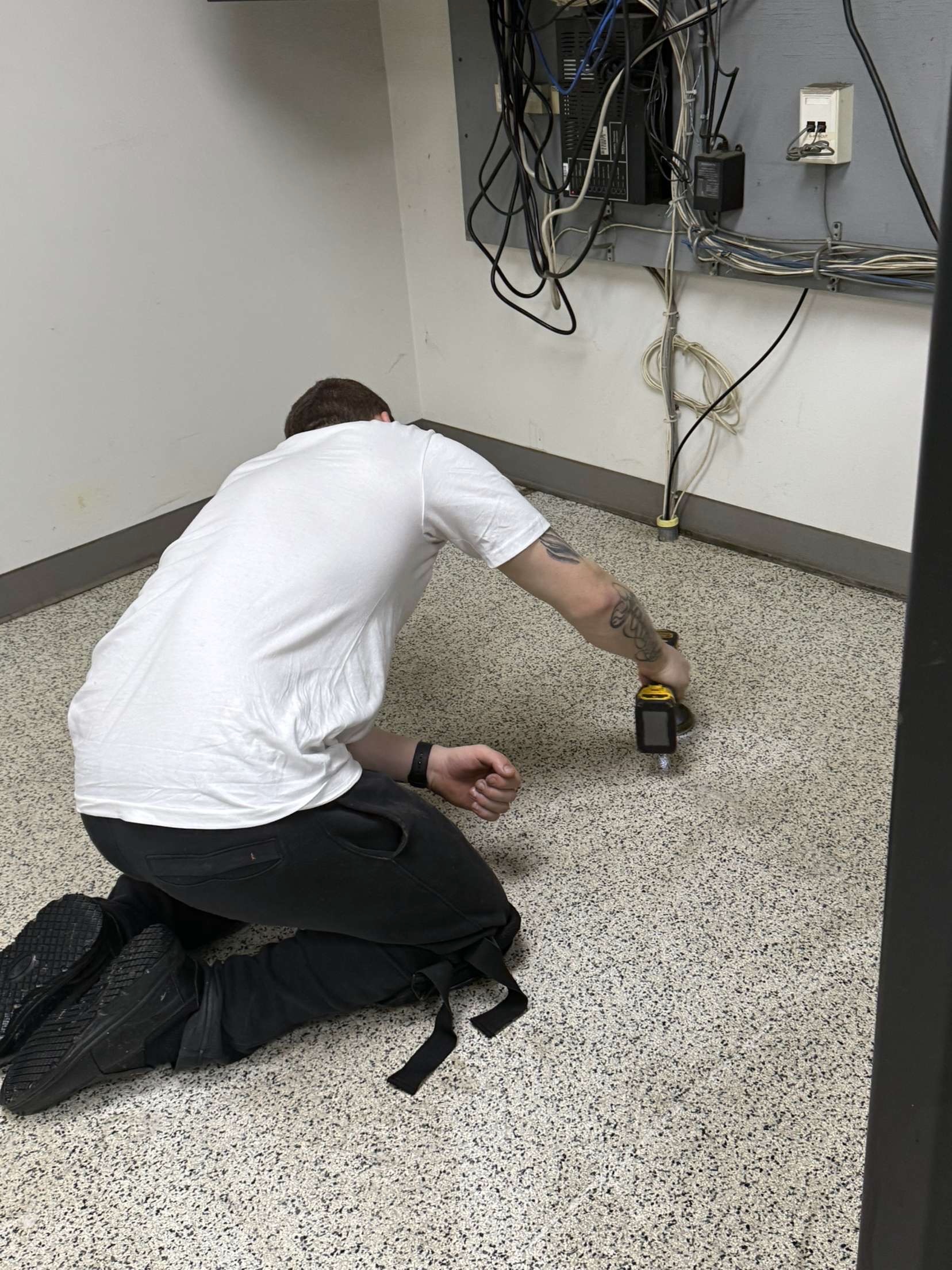Technician scrubbing floor along the baseboard — detail work