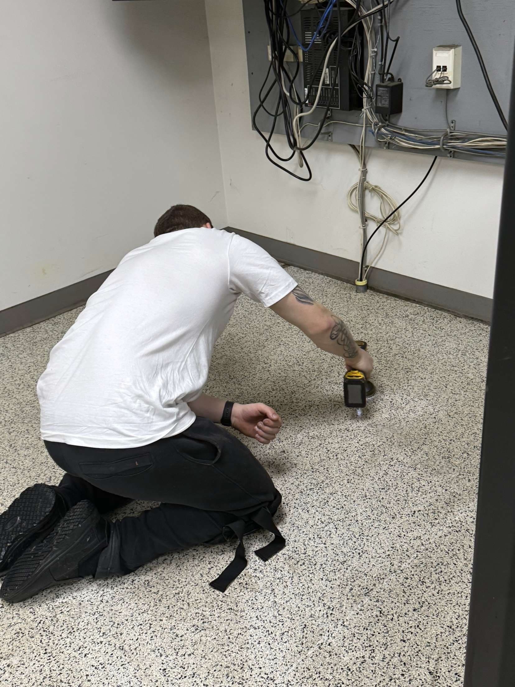 Technician scrubbing floor along the baseboard — detail work